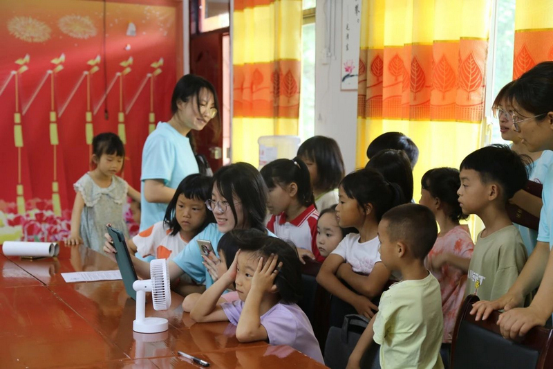 实践团队正带领农村少年儿童观看贵州红色纪念馆云展厅相关学习视频。太阳成集团tyc33455cc官网供图